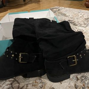 Black medium long boots with a black belt around the ankle.